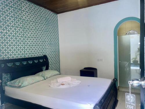 a small bedroom with a bed with a mirror at HOTEL SANTA MONICA in Barranquilla