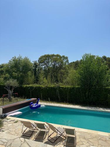 einen Pool mit 2 Stühlen und einer Wasserrutsche in der Unterkunft Maison proche centre de Montpellier au calme in Saint-Clément-de-Rivière