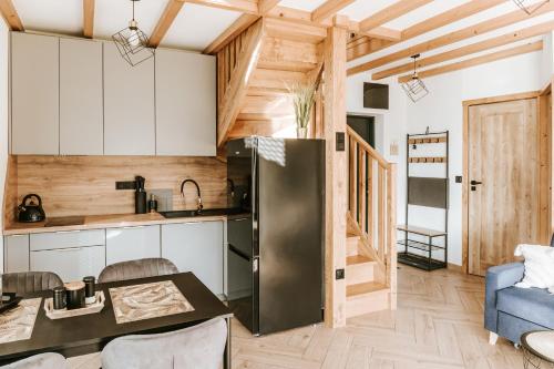 eine Küche mit einem Kühlschrank und einem Tisch im Zimmer in der Unterkunft Domki Bliżej Natury Rabka-Zdrój in Rabka-Zdrój