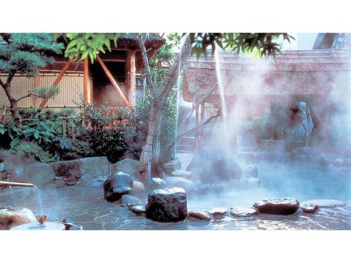 a fountain in a garden with rocks in the water at Asanoya - Vacation STAY 01715v in Shinonsen
