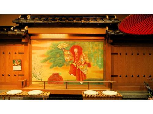 a wall with a painting of a woman with an umbrella at Asanoya - Vacation STAY 01715v in Shinonsen