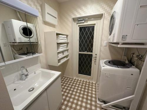 ein Badezimmer mit einem Waschbecken und einer Waschmaschine in der Unterkunft Bears Stay Kumejima Villa - Vacation STAY 01033v in Kumejima