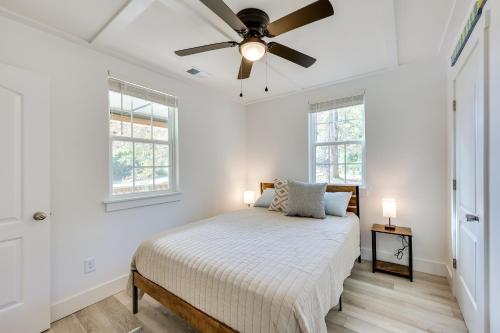 a white bedroom with a bed and a ceiling fan at Rice Creek Hideaway with Private Dock and Boardwalk 