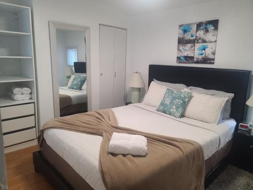 1 dormitorio con 1 cama grande y espejo en Park view South of Boston - Quincy, en Quincy