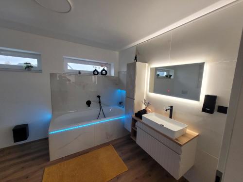 een badkamer met een wit bad en een wastafel bij Ferienwohnung Nachtigall 2 in Bad Hersfeld