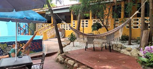 a boy sitting in a hammock in front of a building at Villa Margarita in Puerto Colombia