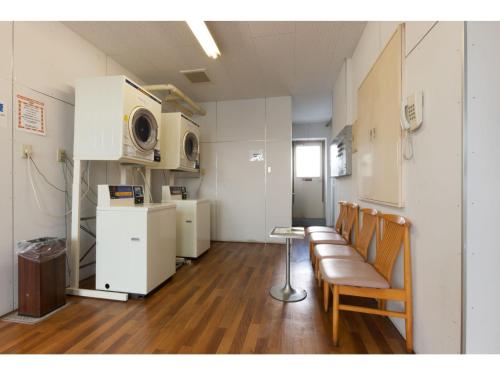 尾道市にあるOnomichi Daiichi Hotel - Vacation STAY 02584vの椅子、テーブル、電子レンジが備わる客室です。