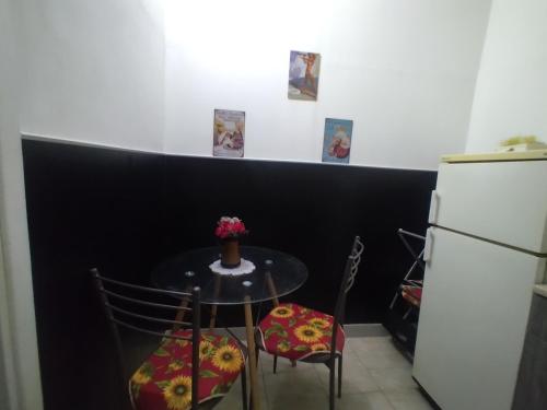 uma mesa e cadeiras numa cozinha com um frigorífico em AL Civico 24 em Acerra