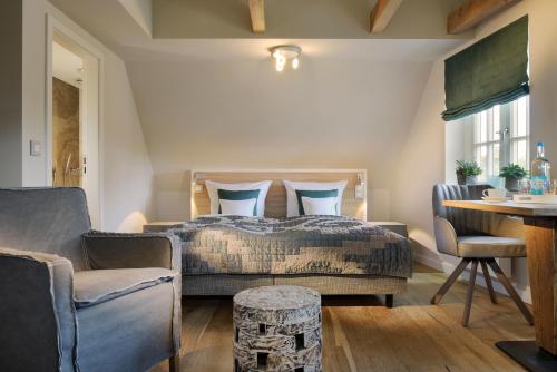 een slaapkamer met een bed en een tafel en stoelen bij Hotel Duene in Rantum