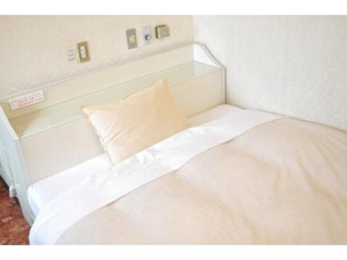 Una cama blanca con una almohada encima. en Green Hotel Rich Tokugawaen - Vacation STAY 02759v, en Okazaki