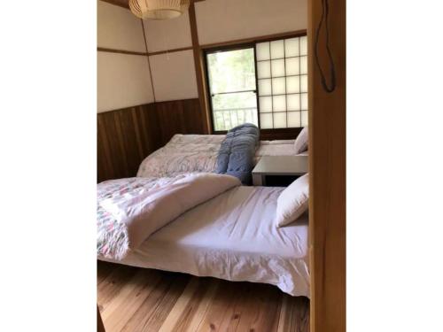 two beds in a room with a window at Hinata Sanso - Vacation STAY 02668v in Azumino