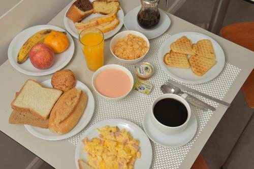 a table topped with plates of breakfast foods and coffee at Bolivian Rooms & Suites (Zona Sur) in La Paz