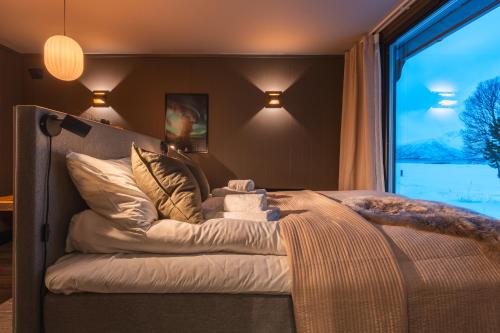 - une chambre avec un lit et une grande fenêtre dans l'établissement Aera - Glass cabins, à Tromsø