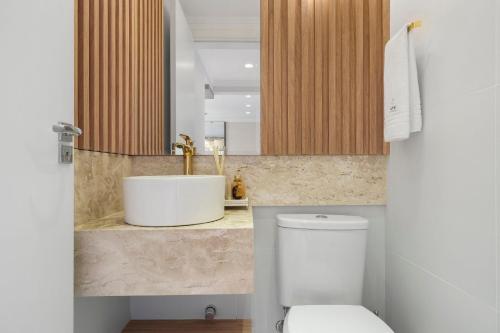 カネラにあるApartamento HodsPrime com 2 Suítes by Acheiの白いトイレと洗面台のあるバスルーム