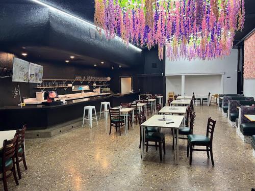 オークランドにあるGarden Inn & Suites Oakland Airportのテーブルと椅子、紫のシャンデリアが備わるレストラン