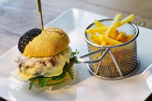 a sandwich and french fries on a white plate at Hotel Duene in Rantum