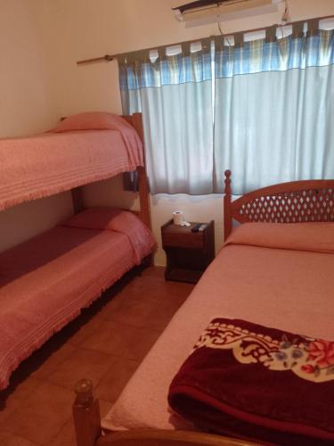a bedroom with two bunk beds and a window at Hospedaje Fátima in Gualeguaychú