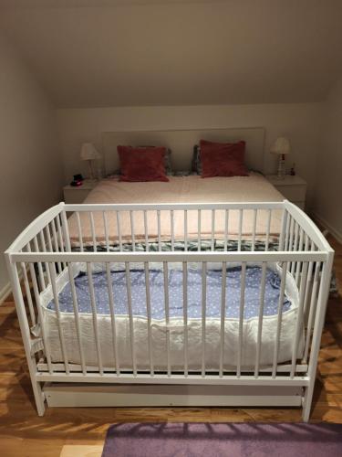 ein weißes Kinderbett in einem Zimmer mit einem Bett in der Unterkunft Sahlin - Kattarp in Kattarp