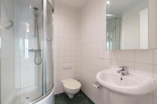 y baño con lavabo, aseo y ducha. en Two bed apartment in Sandyford, en Sandyford
