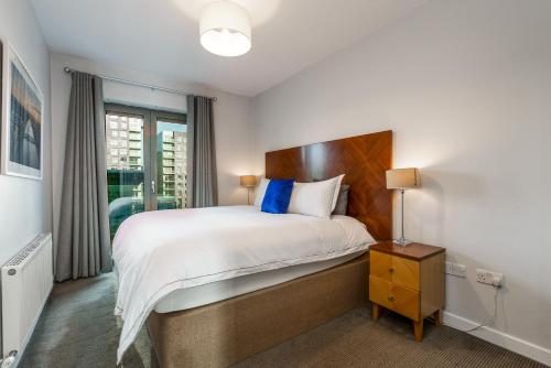 1 dormitorio con 1 cama grande con almohadas azules en Two bed apartment in Sandyford, en Sandyford
