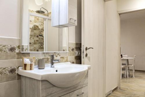 y baño con lavabo blanco y espejo. en Corte dell'Ulivo, en San Giuliano Terme