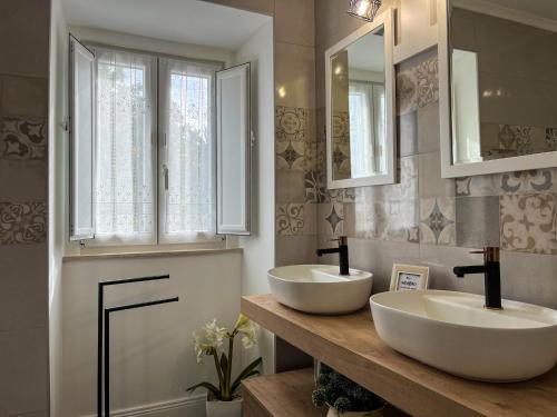 dois lavatórios numa casa de banho com dois espelhos em Casa Tia Maria em Moledo
