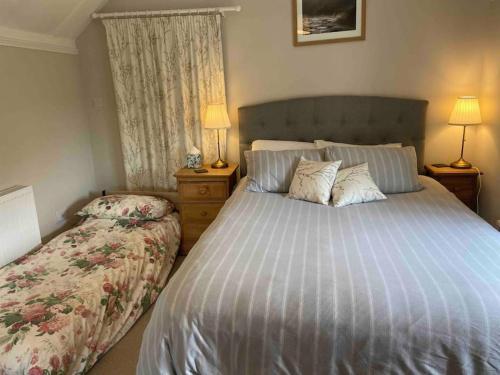 a bedroom with a large bed and a bed sidx sidx sidx sidx at Strongate View Apartment - cosy stylish rural Jurassic coast & Bridport nearby in Netherbury