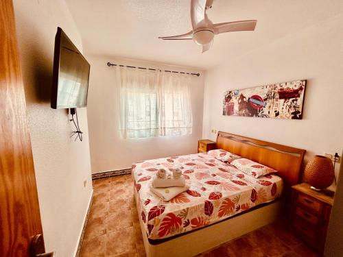 una camera da letto con un letto e un ventilatore a soffitto di Gran Alacant Bea's house a Gran Alacant