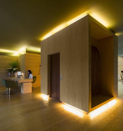 an office with a large wooden wall with a woman sitting at a desk at Monverde - Wine Experience Hotel - by Unlock Hotels in Amarante