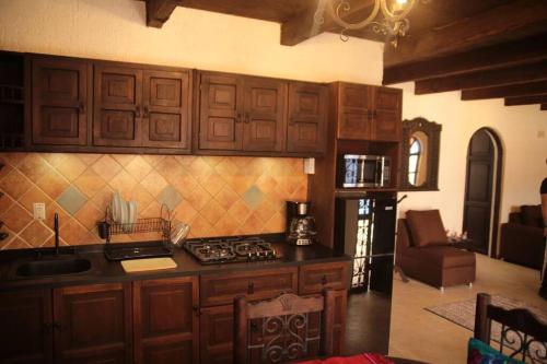 a kitchen with wooden cabinets and a stove top oven at Casa Fátima in San Cristóbal de Las Casas