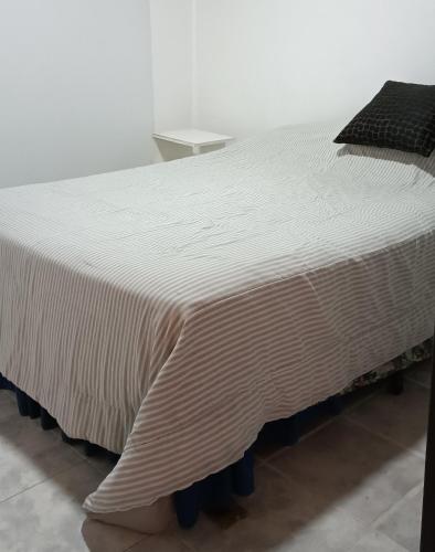 duże białe łóżko z kocem w obiekcie El cardenal w mieście Gualeguaychú