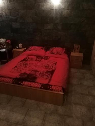 een slaapkamer met een bed met rode lakens en rozen bij Vila Barrandov in Praag