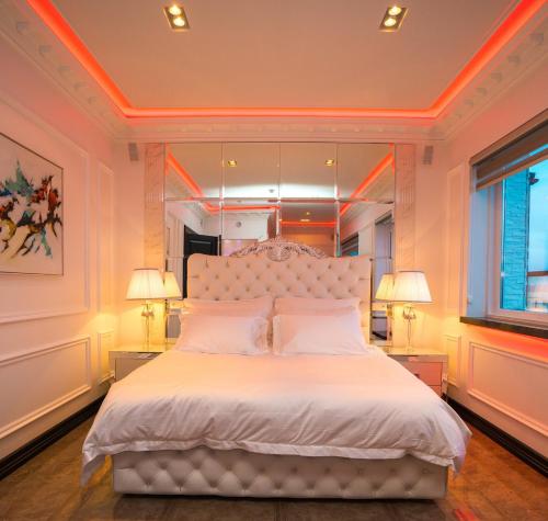 een slaapkamer met een groot wit bed met 2 lampen bij Diamond Suites by Reykjavik Keflavik Airport in Keflavík