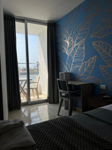 1 dormitorio con cama y escritorio con ventana en Bahia 79 Apartasuites Cerca al Centro en Cartagena de Indias