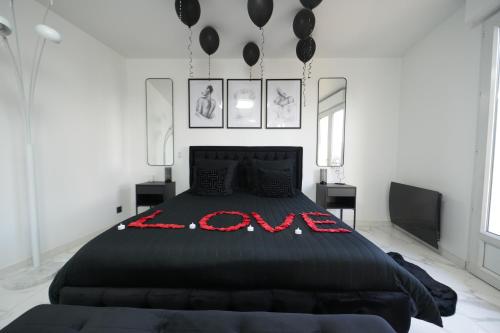 a bedroom with a large black bed with balloons on it at Dammarie-les-Lys : Superbe studio avec jacuzzi in Dammarie-lès-Lys