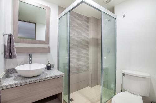 W łazience znajduje się umywalka i przeszklony prysznic. w obiekcie Moderno Mexicano 3BR/2BA 200Mbps w mieście Meksyk