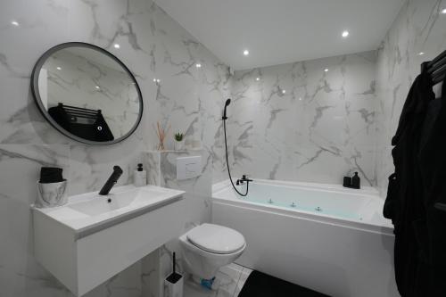 a white bathroom with a sink toilet and a mirror at Dammarie-les-Lys : Superbe studio avec jacuzzi in Dammarie-lès-Lys