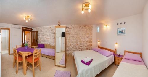 a bedroom with a bed and a table and a kitchen at Apartments Mande and Kate in Baška Voda