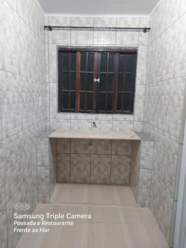 baño con lavabo y ventana en Pousada e Restaurante Frente ao Mar, en Cananéia