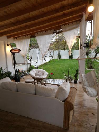 sala de estar con sofá blanco y jardín en The Green House, en Timisoara