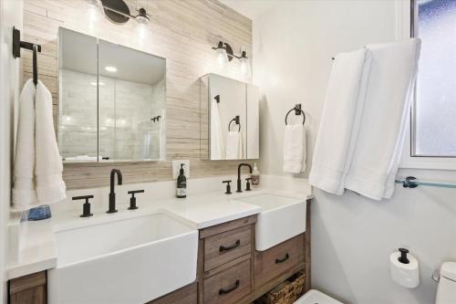 La salle de bains blanche est pourvue d'un lavabo et d'un miroir. dans l'établissement Cobalt Cabin - Beautifully remodeled 3BR with private hot tub, fireplace and dogs ok, à Carnelian Bay