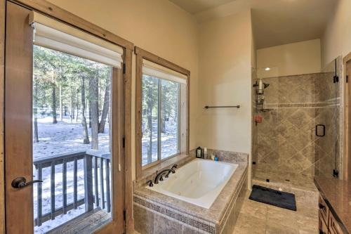 uma casa de banho com uma banheira, um chuveiro e uma janela. em Bluerock Retreat - 3 BR West Shore Cabin - 3 Fireplaces, Short Drive to Skiing em Tahoe City