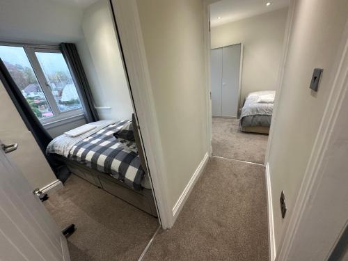 Dormitorio pequeño con cama y espejo en 5 bedroom house in Orpington en Orpington