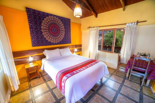 Schlafzimmer mit einem Bett, einem Tisch und einem Fenster in der Unterkunft Hospedaje Chaska Pisac in Pisac