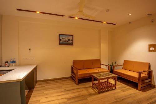 a living room with two chairs and a table at Hotel Stay Bella Kozhikode in Kozhikode