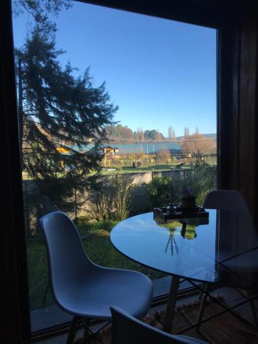 a table and chairs in front of a window at Valdivia Base Camp-Estudio Privado in Valdivia