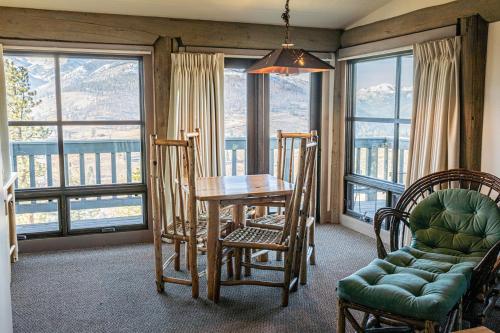 uma sala de jantar com mesa, cadeiras e janelas em Sun Mountain Lodge em Winthrop