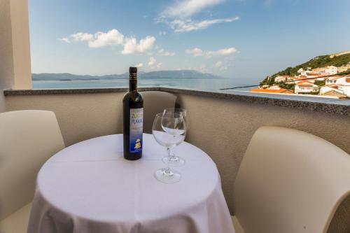a bottle of wine sitting on a table with a glass at Butique Maris in Komarna