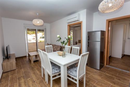 a kitchen and dining room with a white table and chairs at Butique Maris in Komarna