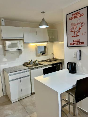 une cuisine avec des placards blancs et un comptoir blanc dans l'établissement Departamento céntrico en Rafaela, à Rafaela